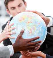 Close-up of a business team holding a terrestrial globe