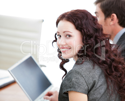 Positive businesswoman smiling at the camera while working at a