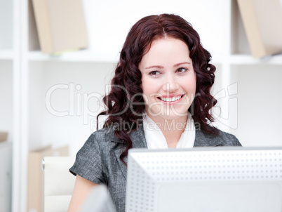 Jolly businesswoman working at a computer