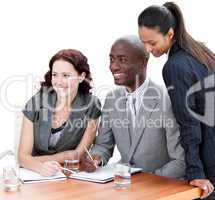 Positive business co-workers studying a document