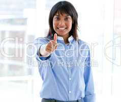 Happy female executive with a thumb up standing