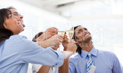 Cheerful multi-ethnic business team toasting with Champagne