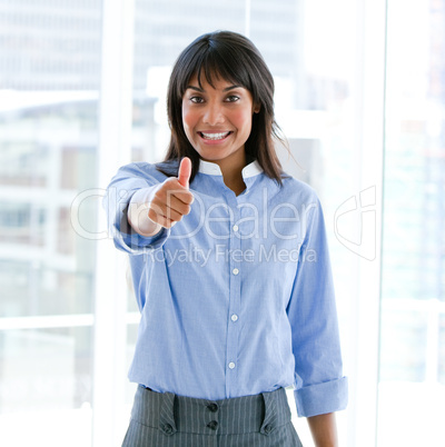 Cheerful female executive with a thumb up standing
