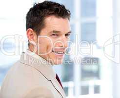 Smiliing businessman with headset on standing