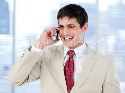 Laghing businessman talking on phone standing
