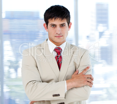 Self-assured businessman with folded arms standing