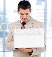 Concentrated businessman using a laptop standing