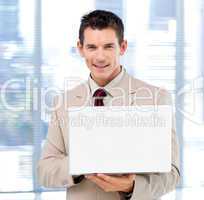 Handsome businessman using a laptop standing