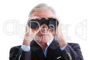 Serious businessman looking through binoculars standing