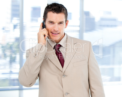 Assertive businessman talking on phone standing