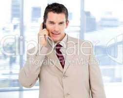 Assertive businessman talking on phone standing