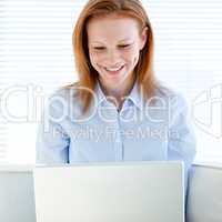 Joyful business woman working on a laptop computer