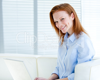 Smiling business woman working on a laptop computer