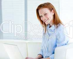 Smiling business woman working on a laptop computer