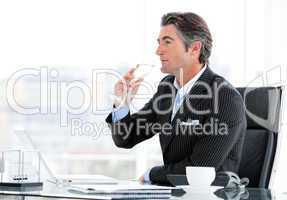 Charismatic businessman drinking a glass of water
