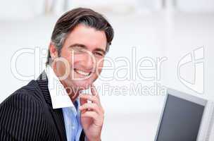 Smiling businessman working at a computer