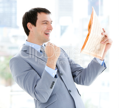 Happy businessman reading a newspaper