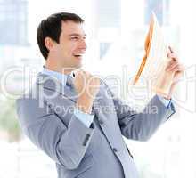 Happy businessman reading a newspaper