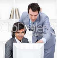 Two confident business partners working at a computer