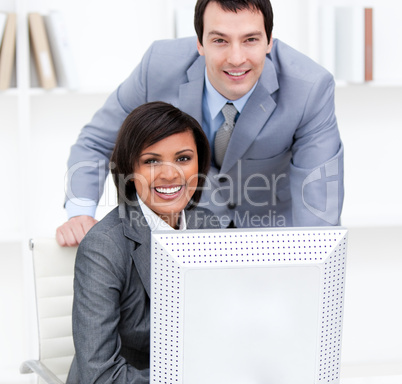 Two young business partners working at a computer