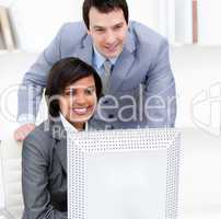 Two business partners working at a computer