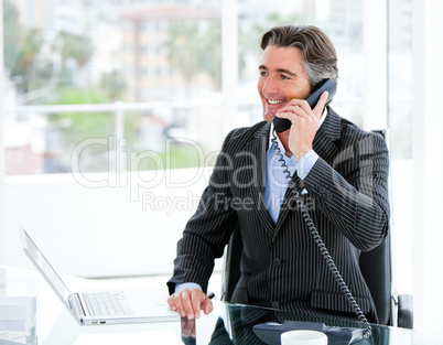 Smiling mature businessman talking on phone