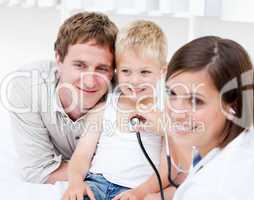 Portrait of beautiful female doctor examining a little boy with
