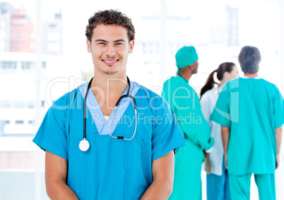 Handsome male doctor looking at the camera while his medical par