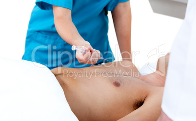 Doctor using a syringe to reanimate an inconscious patient