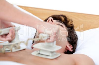 Male doctor using the defibrillator to reanimate an inconscious