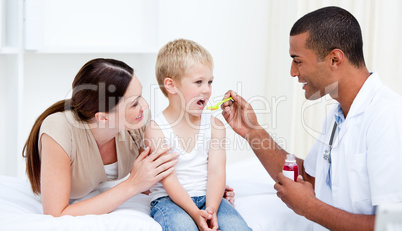 Mixed-race doctor giving some syrup to the little boy