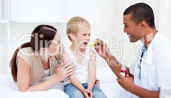 Mixed-race doctor giving some syrup to the little boy