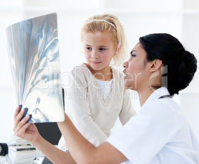 Confident female doctor showing an x-ray to a little girl
