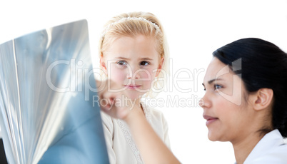 Attentive female doctor showing an x-ray to a little girl