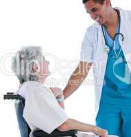Senior patient sitting on a wheelchair talking with her doctor