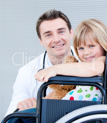 Cute little girl sitting on a wheelchair with her doctor