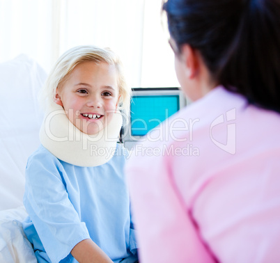 Adorable little girl with a neck brace talking with a nurse