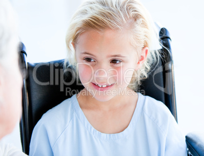 Blond little girl sitting on a wheelchair