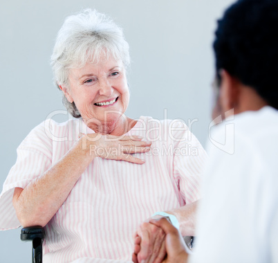 Senior woman sitting on a wheelchair talking with her doctor
