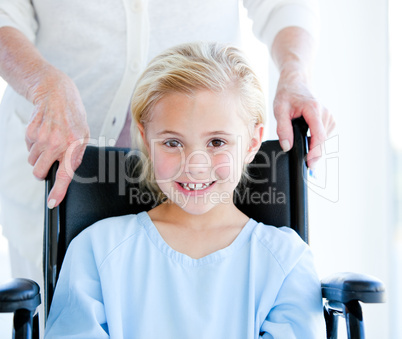 Adorable little girl sitting on a wheelchair
