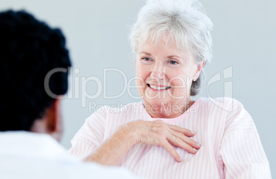 Smiling senior patient sitting on a wheelchair talking with her