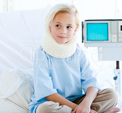 Little girl with a neck brace sitting on a hospital bed