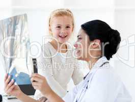 Caring female doctor showing an x-ray to a little girl