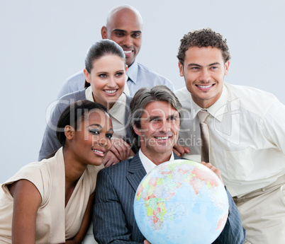 Multi-ethnic businessteam holding a globe in the office