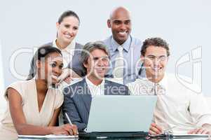 Smiling internationnal businessteam working with at the laptop