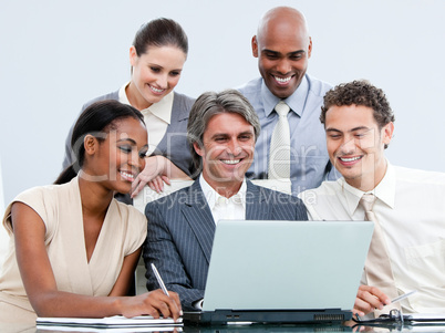 Happy mixed businessteam looking at the laptop