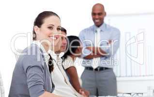 Smiling businesswoman looking at the camera during a meeting wit