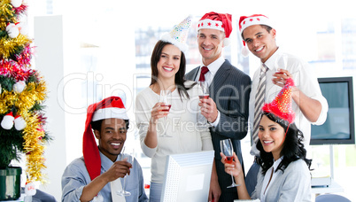 Smiling business team drinking champagne to celebrate christmas