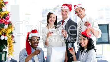Smiling business team drinking champagne to celebrate christmas
