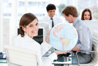 Confident businesswoman holding a globe